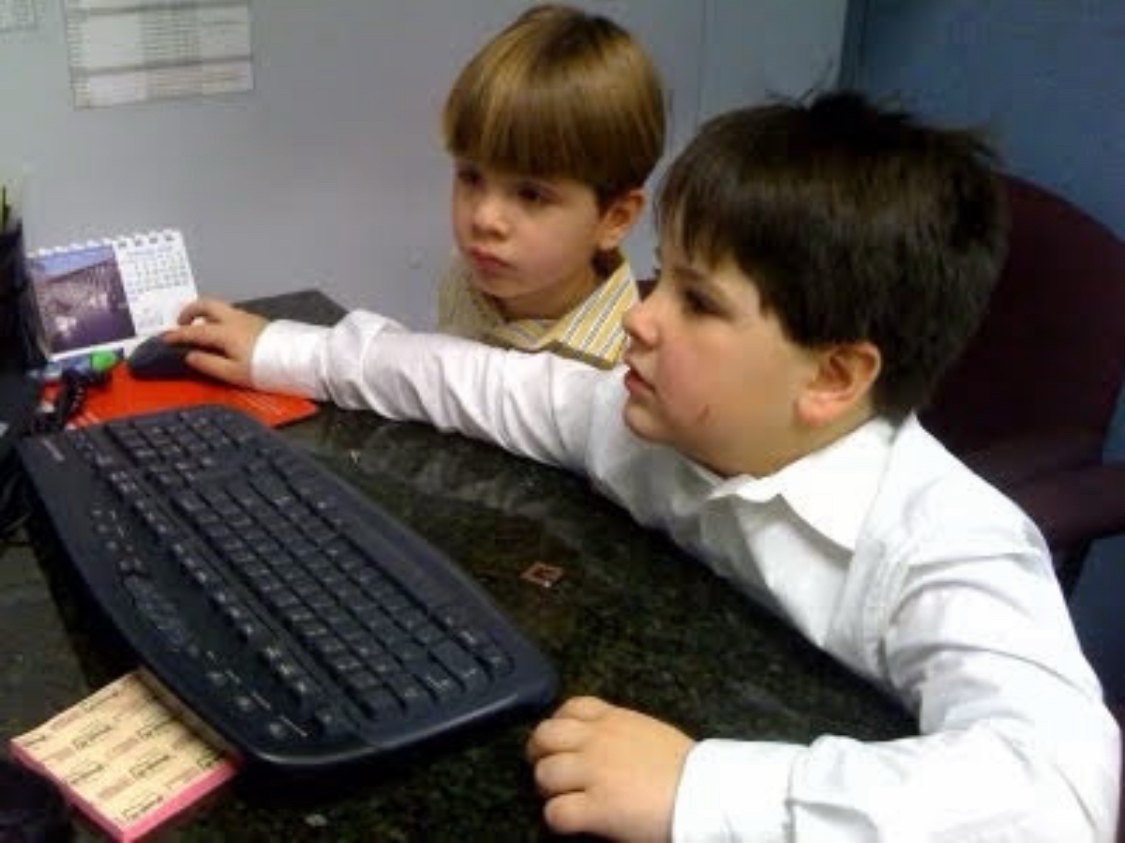 Two young boys, Nathan and Filipe, at a computer in the office