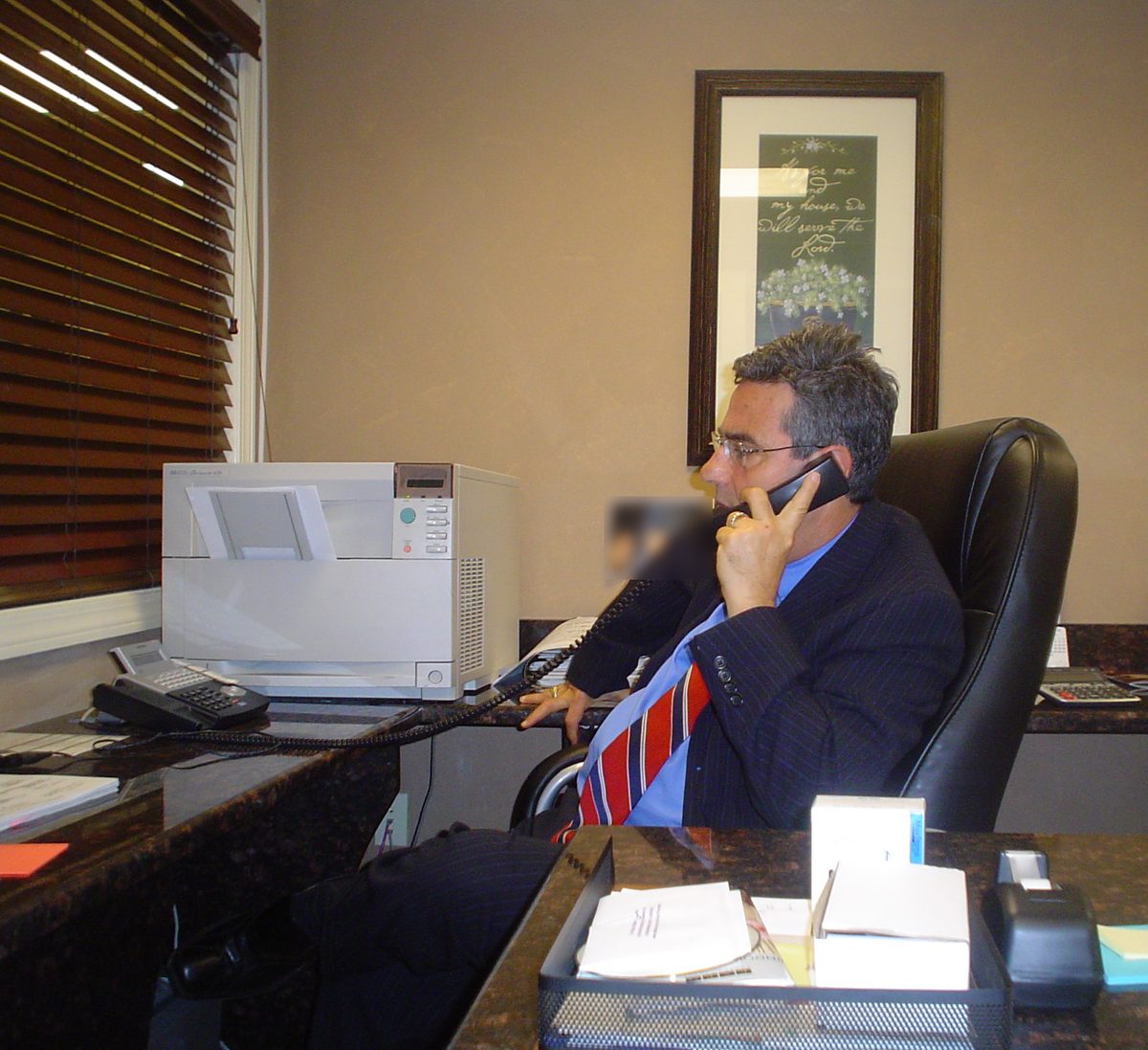 Marcos Gomes on the phone at his desk in the Somerville office